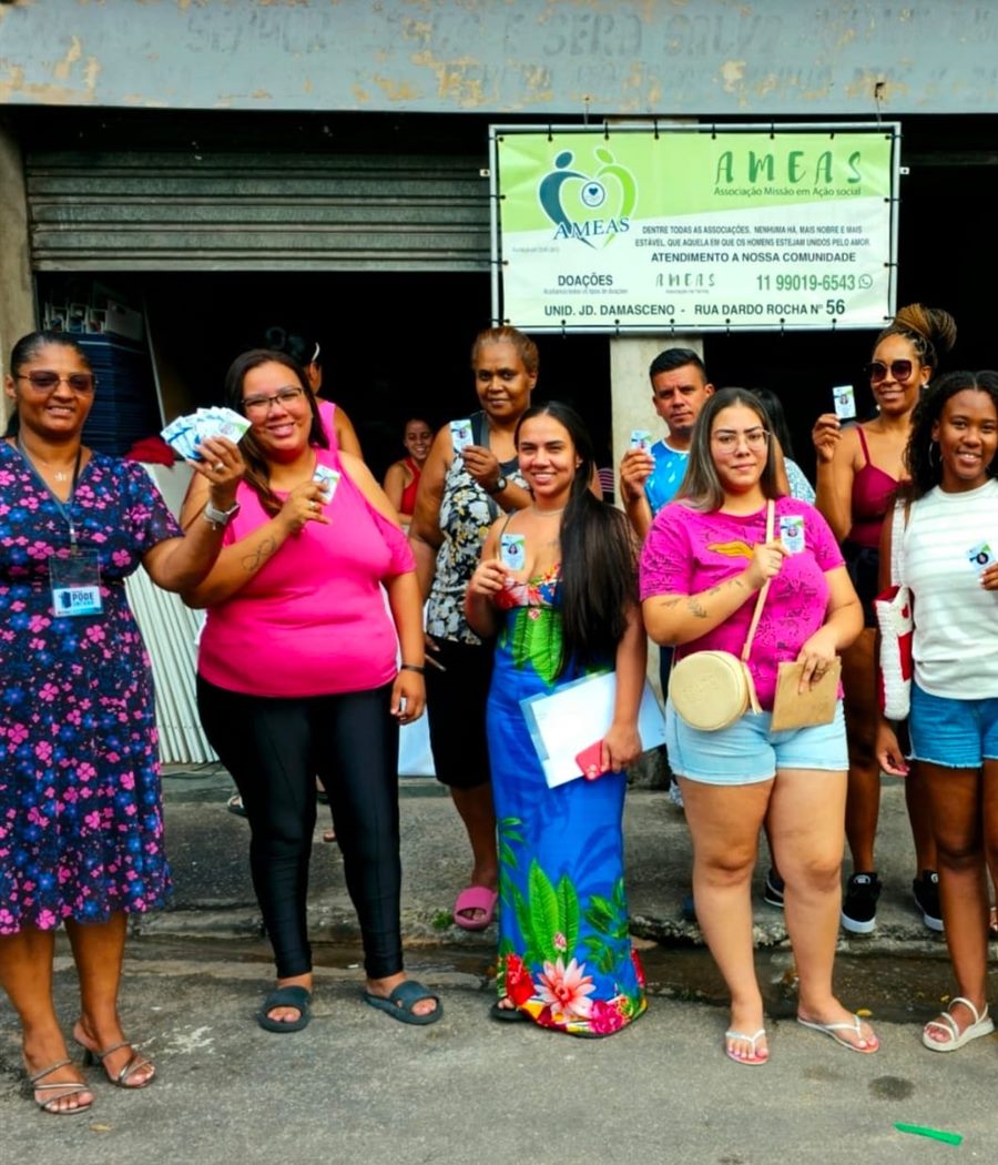 Moradoras e voluntárias reunidas diante da faixa do Instituto AMEAS na sede da Rua Dardo Rocha, no Jardim Damasceno.