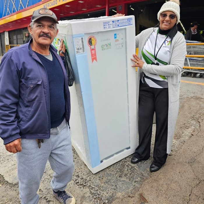 Morador recebe um eletrodoméstico entregue em ação do programa habitacional.